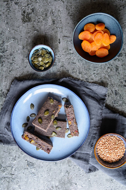 Poppy seed energy bars with dried apricot, dates, pumpkin seeds, buckwheat and honey - Photo, Image