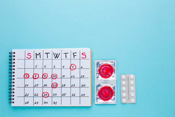 womans hands with birth control pills and condom - Φωτογραφία, εικόνα