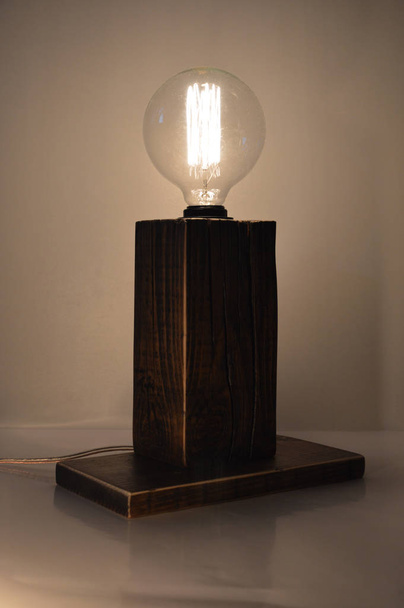 Деревянная лампа ручной работы на сером фоне
 - Фото, изображение