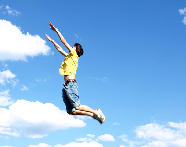 young man jumping on the sky background - 写真・画像