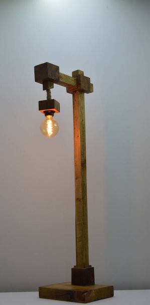 Lámpara de madera hecha a mano sobre fondo gris
 - Foto, Imagen