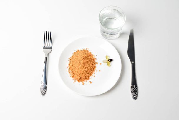 Tomato protein soup powder on a spoon. Hand puts the powder into the glass of water. Meal replacement. Dry soup. Multivitamins, astaxanthin, fish oil, omega pills.  Closeup. - Foto, immagini