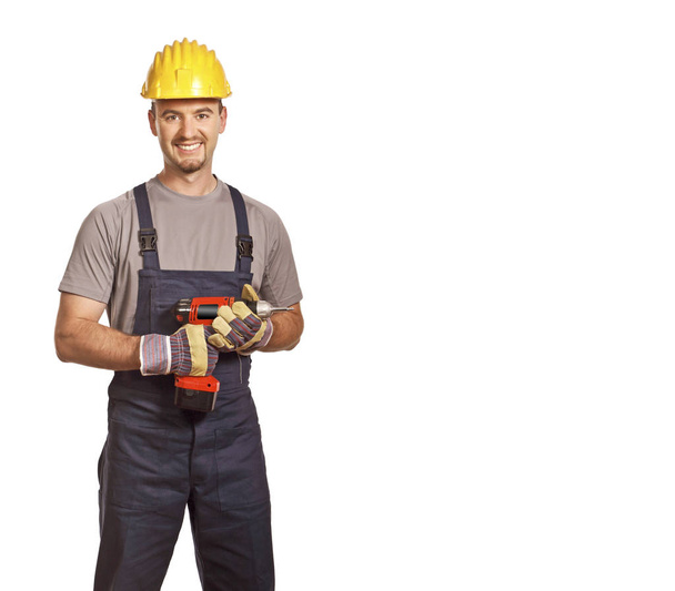 portrait of a smiling builder with a drill isolated on white background - Zdjęcie, obraz