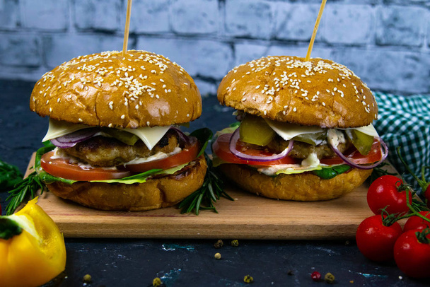Deux burgers de bœuf maison aux champignons, micro-verts, oignon rouge sur planche à découper en bois
 - Photo, image