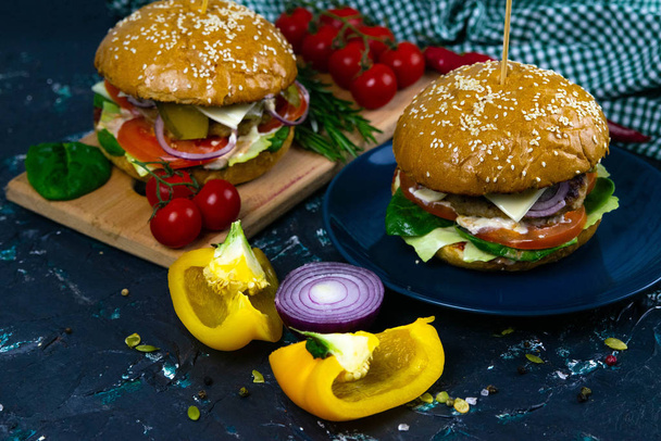 Deux burgers de bœuf maison aux champignons, micro-verts, oignon rouge sur planche à découper en bois
 - Photo, image