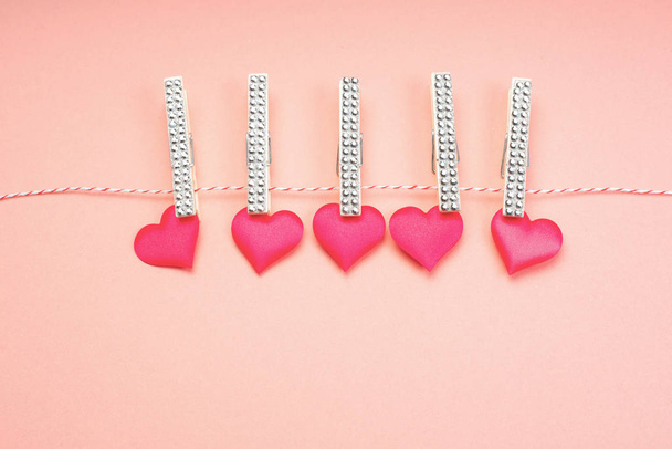 Valentines Day . Blank for the designer. Valentines day concept. Greeting card. Copy spice. Pink hearts hanging on clothespins on a pink background. - Photo, Image