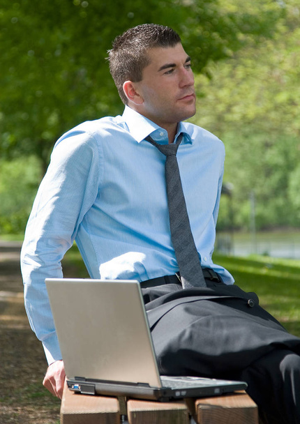 businessman sitting on bench in park - Фото, зображення