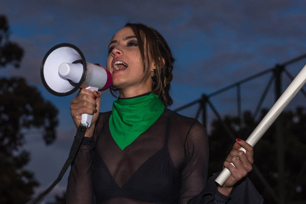 beautiful activist with green bandana in her neck and megaphone  - Photo, Image