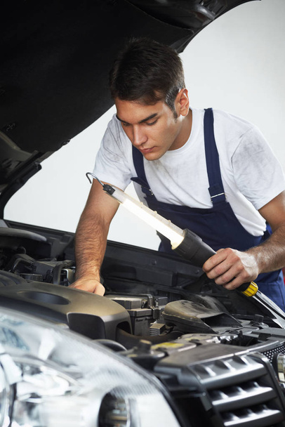 mechanic examining car tire at garage - Fotografie, Obrázek