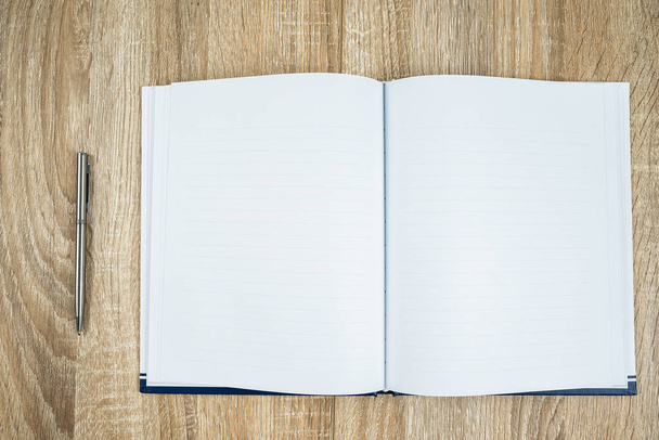 leeres Notizbuch-Tagebuch mit silbernem Stift auf Holztisch - Foto, Bild