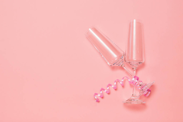 Dos copas de champán con una cinta rosa sobre un fondo rosa
. - Foto, Imagen