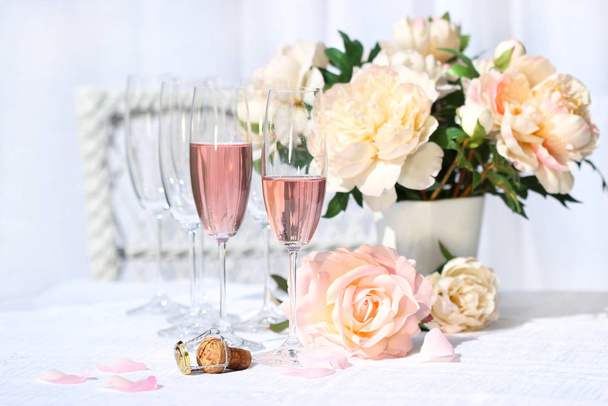 Two glasses filled with pink Champagne with flowers  - Foto, imagen