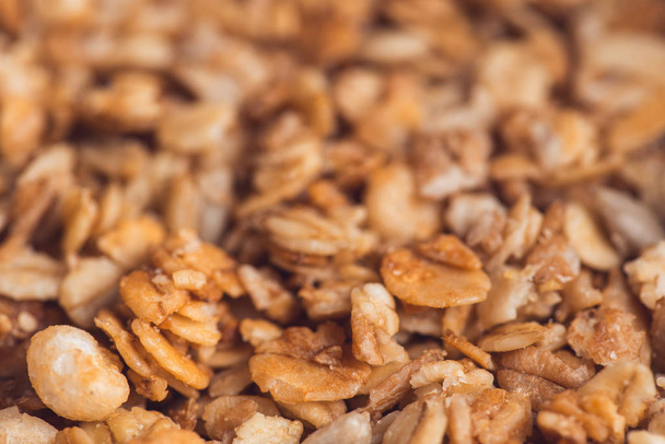 Useful and tasty muesli with nuts, rasins and flakes. Selective focus macro shot with very shallow depth of field. Healthy and vegetarian lifestyle - Zdjęcie, obraz