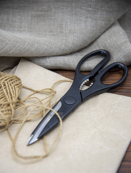 Tools for crafts on a wooden table top. Scissors, thread and paper. - Fotografie, Obrázek