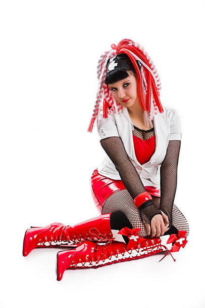 νεαρή γυναίκα με κόκκινο κορσέ και γάντια με παπιγιόν - Φωτογραφία, εικόνα