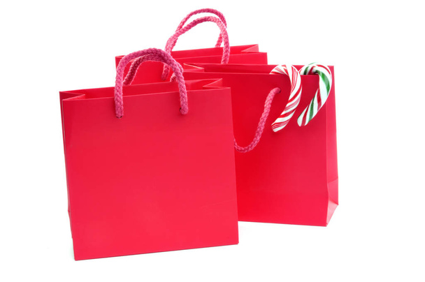 three red bags with candy canes and copy space - Фото, изображение