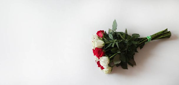 Stelletje rode en witte rozen op blanco oppervlak met kopieerruimte voor tekst - Foto, afbeelding