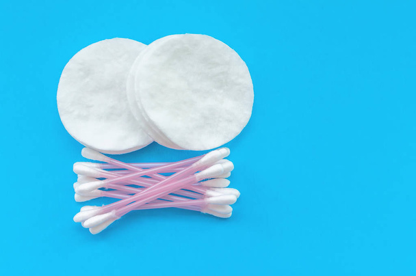 Cotton pads and cotton sticks on a blue background with a place for writing. The concept of body care. - Фото, зображення
