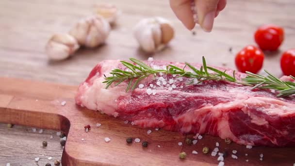 Rauw vers vlees Steak met kruiden en specerijen op rustieke achtergrond - Video