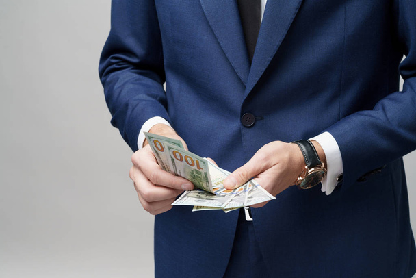 young handsome businessman holding US dollar bills - Fotó, kép