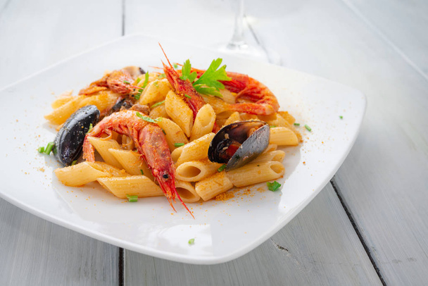 Penne allo scoglio, prato de massas italianas com crustáceos, moluscos e bottarga
  - Foto, Imagem