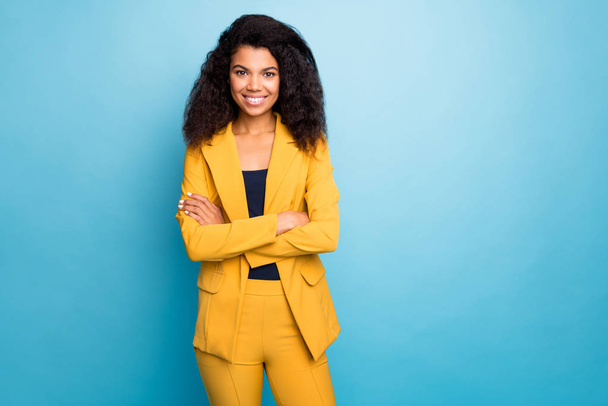 Photo of beautiful dark skin business lady holding hands crossed self-confident bossy person worker wear stylish yellow office costume isolated blue color background - 写真・画像