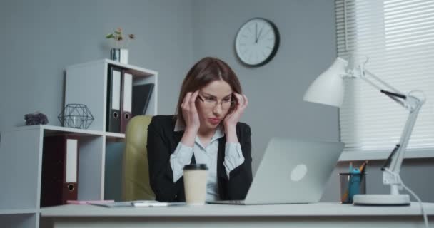 Businesswoman is tired and feels stressed out. Feeling tired and stressed. Frustrated young woman keeping eyes closed while sitting at her working place in office. - Πλάνα, βίντεο