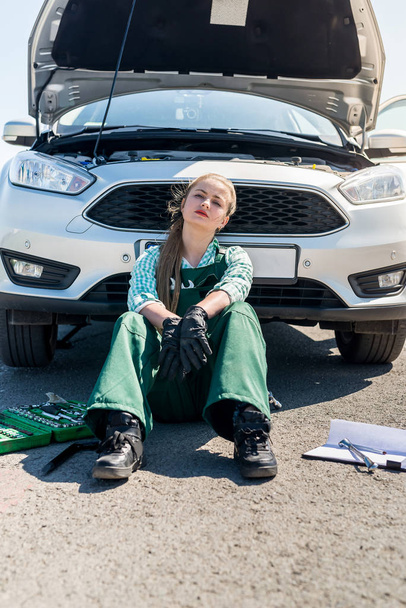 Väsynyt nainen mekaanikko rikki auto tienvarsilla
 - Valokuva, kuva