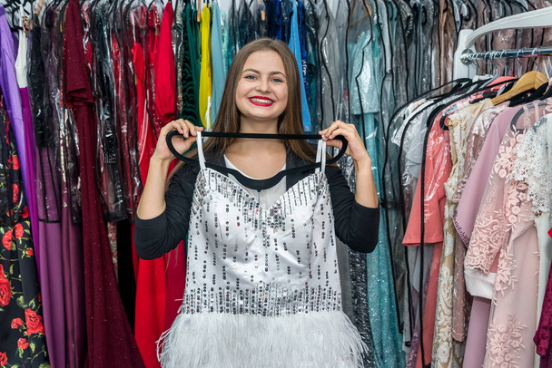 Mujer joven probar hermoso vestido de cóctel en la tienda
 - Foto, Imagen