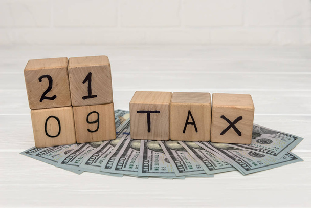 Деревянные кубики с текстовым налогом 2019 года на долларовые купюры
  - Фото, изображение
