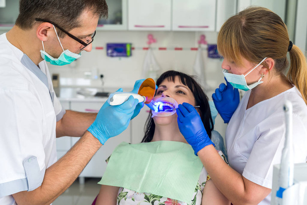 Dentista e enfermeiro que trabalham com o paciente na odontologia
 - Foto, Imagem