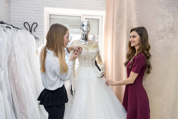 Les jeunes femmes dans le salon de mariage choisir robe
 - Photo, image