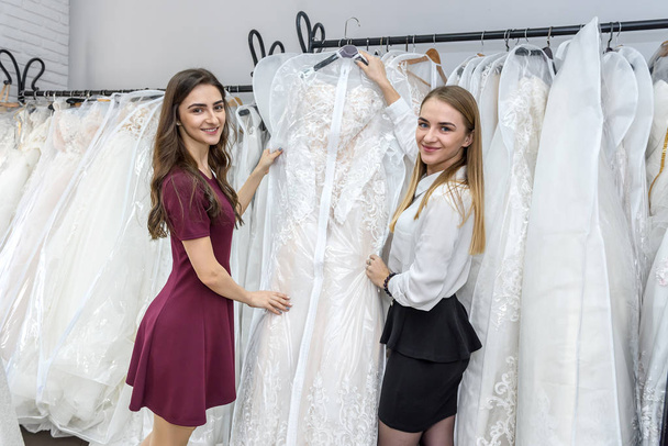 Young women in wedding salon choosing dress - 写真・画像