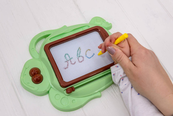 Child's education with plastic magnetic rewritable board - Foto, imagen