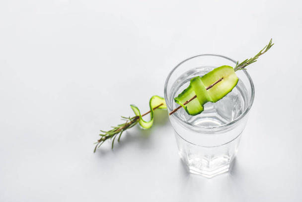 Glass of cold cucumber water on light background - Foto, Imagen