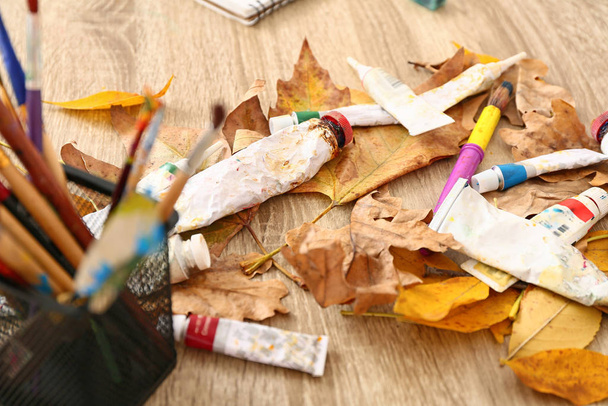絵具と秋の葉をテーブルの上にチューブ - 写真・画像