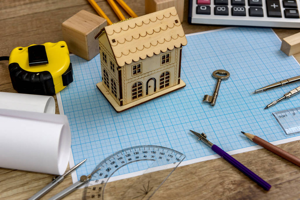 Holzhausmodell mit Schlüssel auf Millimeterpapier - Foto, Bild