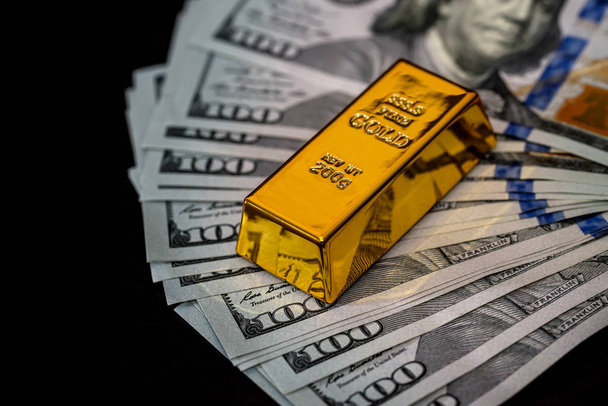 Dollar bankbiljetten op zwarte achtergrond met goud - Foto, afbeelding