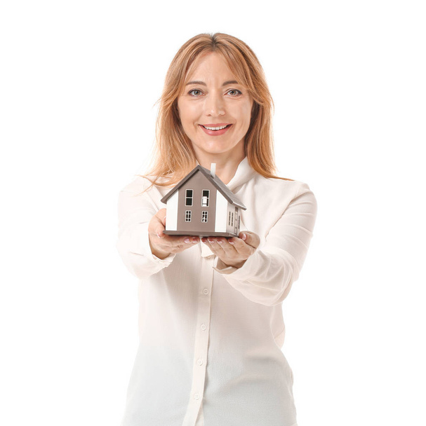 Agente inmobiliario femenino con modelo de casa sobre fondo blanco
 - Foto, Imagen