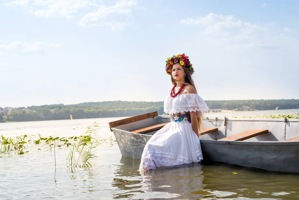 Belle fille en vêtements nationaux debout dans le lac
 - Photo, image