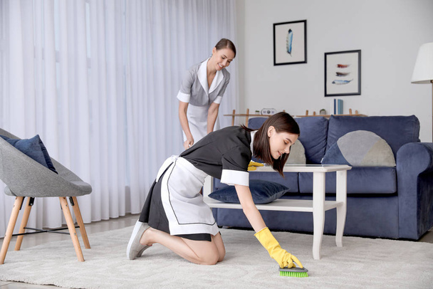 Gyönyörű fiatal szobalányok takarítják a hotelszobát. - Fotó, kép