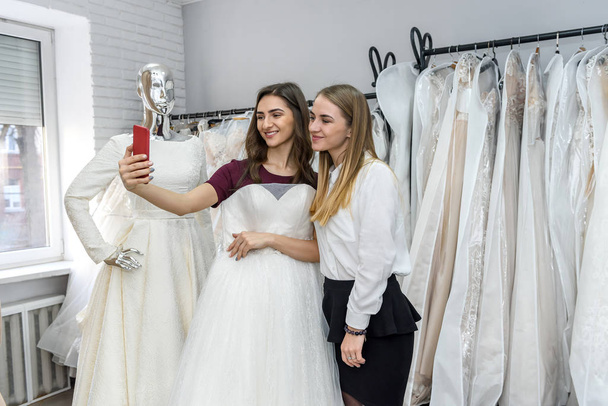 Dvě krásné dívky dělat selfie ve svatebním salonu - Fotografie, Obrázek