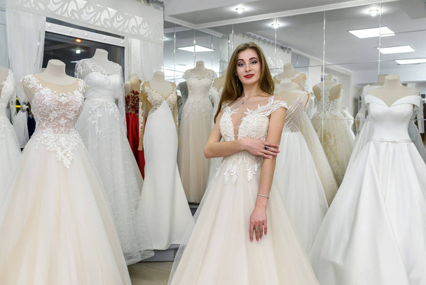Belle mariée en robe de mariée debout en boutique
 - Photo, image