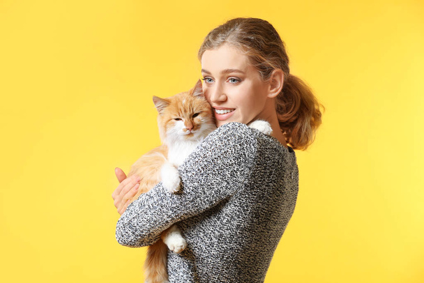 Gyönyörű fiatal nő, aranyos macska, a háttér színét - Fotó, kép