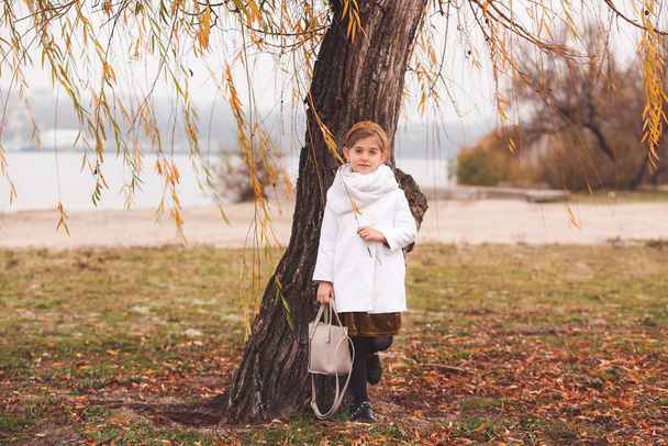 Χαριτωμένο κοριτσάκι με φθινοπωρινά ρούχα έξω - Φωτογραφία, εικόνα