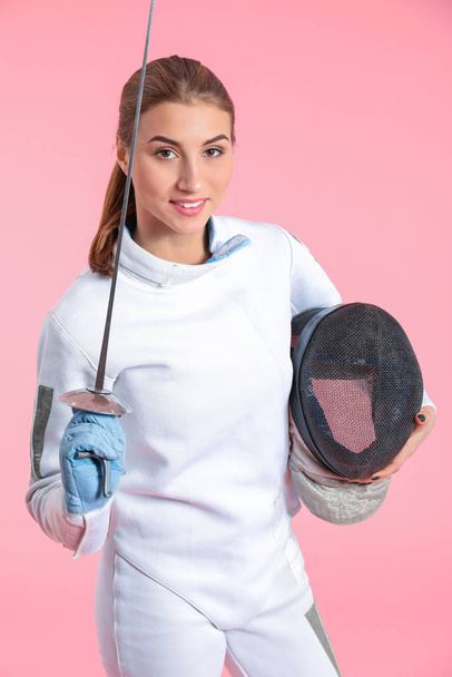 Young female fencer on color background - Photo, image