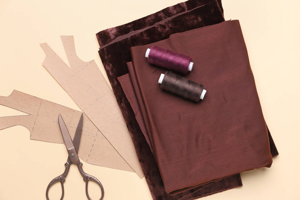 Set van kleermakersbenodigdheden met naaipatroon op kleur achtergrond - Foto, afbeelding