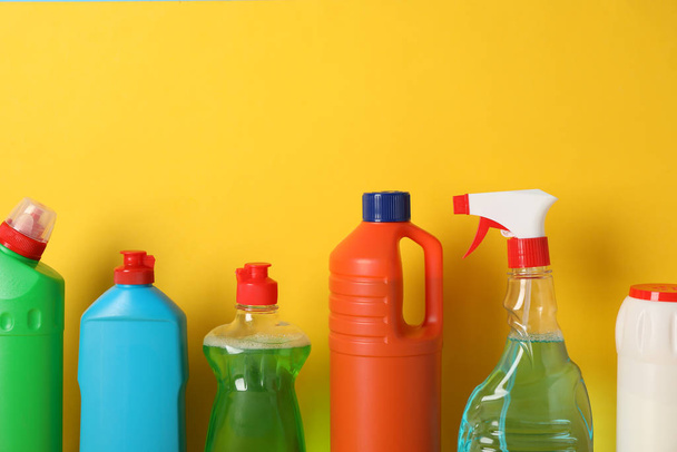 Gruppe von Flaschen mit Waschmittel auf gelbem Hintergrund, Platz für  - Foto, Bild
