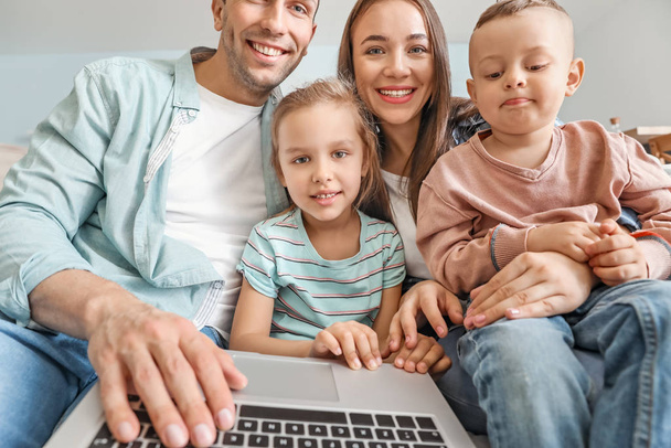 Νεαρή οικογένεια με φορητό υπολογιστή συνομιλίας στο σπίτι - Φωτογραφία, εικόνα