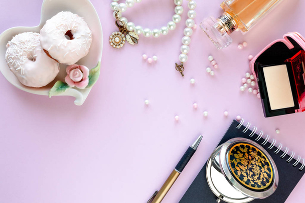 Fashion blogger workspace with laptop and female accessory, cosmetics products on pale pink table. Sweets, donuts, macaroons and gifts for the holiday Valentine's Day. flat lay, top view - Photo, Image
